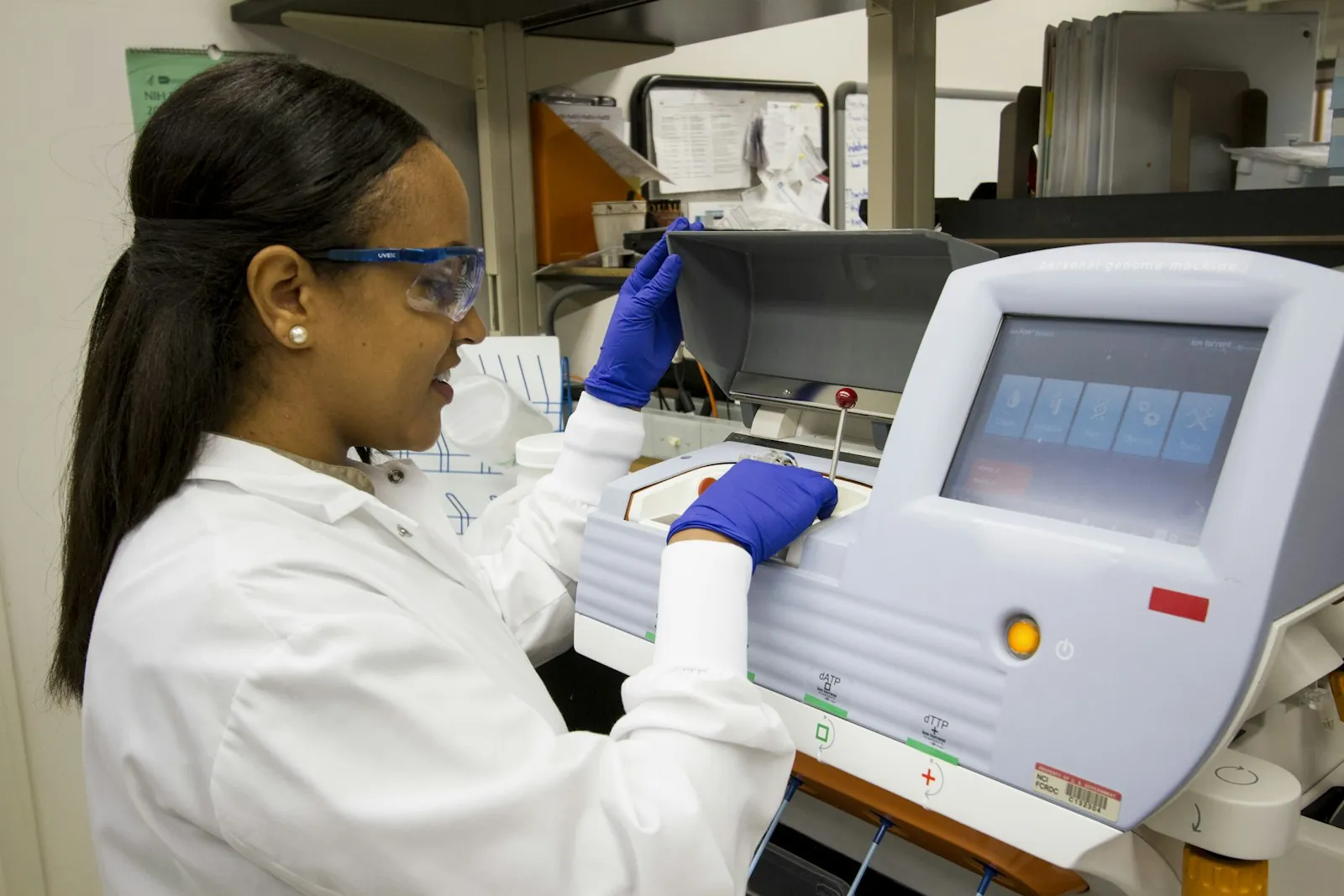A laboratory scientist loading samples into an analyser